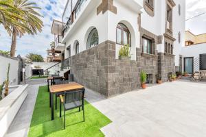 un patio con mesa y sillas frente a un edificio en Sweet garden Las palmas en Las Palmas de Gran Canaria