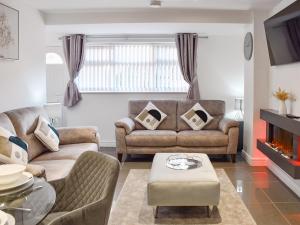 a living room with a couch and a table at The Farmhouse - Uk42780 in Hemsby