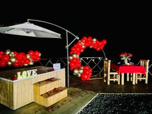 a bunch of red balloons on a deck with a table at Ecofuratena Glamping & Experience in Utica