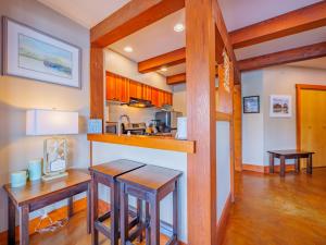 a kitchen with two bar stools and a counter top at Whisky Harbour, Downtown King Bed and Inlet View in Ucluelet