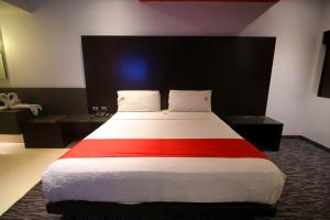 a bedroom with a bed with a red stripe on it at Motel Via in Tijuana