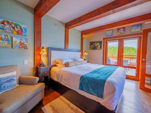 a bedroom with a bed and a couch and a window at Whisky Harbour, Downtown King Bed and Inlet View in Ucluelet