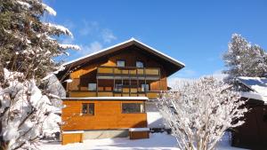 a large wooden building in the snow with trees at Haus Vital, Rottmann in Altenmarkt im Pongau