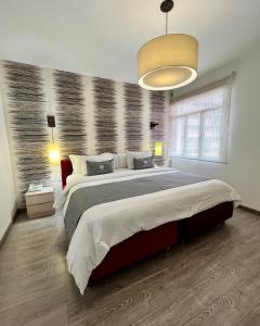 a bedroom with a large bed and a large window at Hotel Ciudad Bonita in Bucaramanga