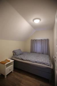a small bedroom with a bed with a curtain at Sentral leilighet med 3 soverom 2etg in Harstad