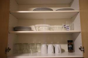 a cupboard with plates and bowls and glasses at Sentral leilighet med 3 soverom 2etg in Harstad