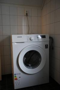 uma máquina de lavar roupa num canto de um quarto em Sentral leilighet med 3 soverom 2etg em Harstad