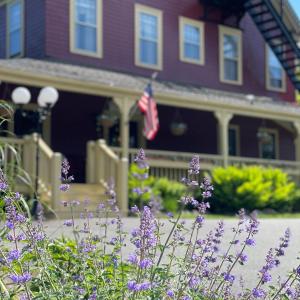 una casa con flores púrpuras delante de ella en Central House Inn, en Bar Harbor