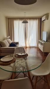 sala de estar con mesa de cristal y sillas blancas en Departamento en Nueva Córdoba en Córdoba