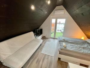 een slaapkamer met een bed en een raam op zolder bij Felix House Siófok in Siófok