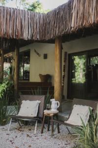 2 Stühle und ein Tisch vor einem Haus in der Unterkunft CASA SUKHA Hotel in Trancoso