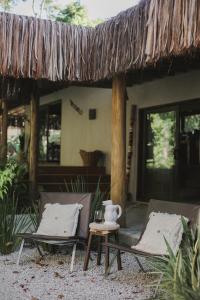 duas cadeiras e uma mesa em frente a uma casa em CASA SUKHA Hotel em Trancoso