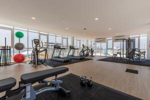 a gym with treadmills and exercise equipment in a building at Aruba Dreams, Take Me Away Studio in Oranjestad