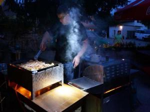 Mężczyzna gotuje jedzenie na grillu. w obiekcie Privat Bohemia w mieście Šatov