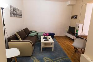een woonkamer met een bank en een tafel bij S&N Apartments Nis in Niš