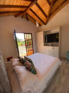 Un dormitorio con una gran cama blanca y una ventana en FINCA VILLA CRISTINA, en La Fuente