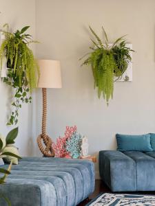 a living room with a blue couch and plants at Luna House in Cascais