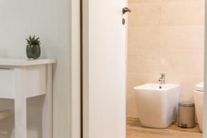 - une salle de bains avec un urinoir à côté des toilettes dans l'établissement Centro storico Sciacca - Casa Di Pisa, à Sciacca