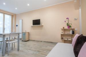 ein Wohnzimmer mit einem Tisch und einem TV an der Wand in der Unterkunft Good Time Apartment in Ciampino