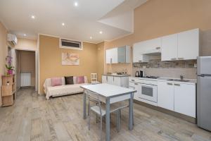a kitchen and living room with a table and a couch at Good Time Apartment in Ciampino