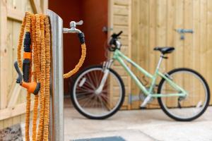 a bike is hooked up to a wall with ropes at Linhay at East Trenean Farm -Luxury retreat for 2 with stunning rural views, private hot tub and EV charging in Looe