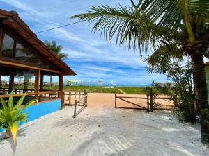 a building on the beach with a palm tree at Pousada Loin de Tout in Corumbau