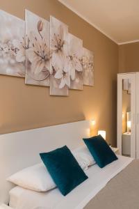 sypialnia z białym łóżkiem z 2 niebieskimi poduszkami w obiekcie Good Time Apartment w Ciampino