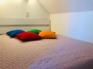 - 2 oreillers colorés installés sur un lit dans la chambre dans l'établissement Nida Four Seasons, à Nido