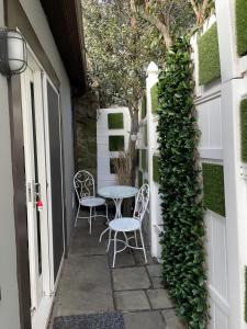 a patio with two chairs and a table and a vine at California guest house in Greenwich