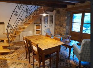 een eetkamer met een houten tafel en een trap bij Casa Chidro in Buesa