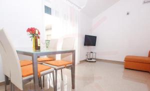 sala de estar con mesa, sillas y TV en Stari Dvori, en Trogir