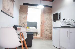 Il comprend une cuisine et un salon avec une table et des chaises. dans l'établissement Caleros 8 Estudio - Apartamentos de la Parte Antigua de Cáceres, à Cáceres