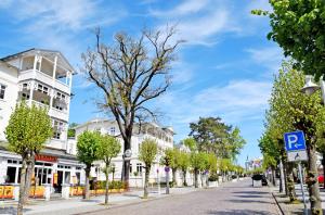 una calle en una ciudad con edificios blancos y árboles en schöne Ferienwohnungen mit Kamin im Ostseebad Sellin Kopie en Ostseebad Sellin