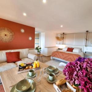 a living room with a table and a bed at L'ÉCHAPPÉE BRETONNE in Plouider