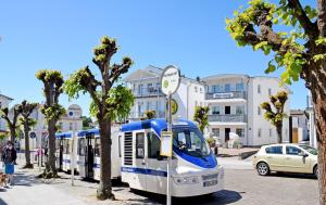 Un autobús blanco y azul estacionado en una calle de la ciudad en schöne Ferienwohnungen mit Kamin im Ostseebad Sellin Kopie en Ostseebad Sellin