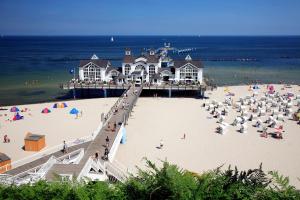 a pier on a beach with people on the beach at schöne Ferienwohnungen mit Kamin im Ostseebad Sellin Kopie in Ostseebad Sellin