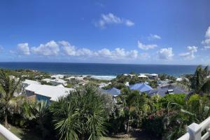 a view of the ocean from the balcony of a resort at Horizon bleu Caraibes in Le Moule