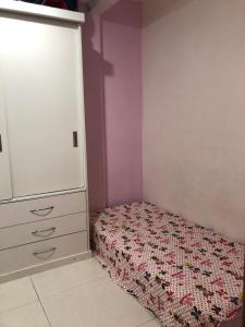 a small bedroom with a bed and a dresser at Cobertura com Piscina na Lapa in Rio de Janeiro