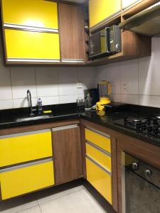 a kitchen with wooden cabinets and yellow drawers at Cobertura com Piscina na Lapa in Rio de Janeiro