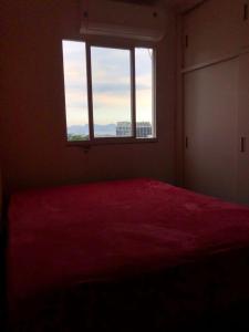 1 dormitorio con cama roja y ventana en Cobertura com Piscina na Lapa, en Río de Janeiro