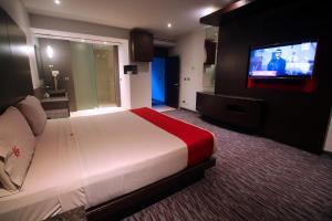 a hotel room with a bed and a flat screen tv at Motel Via in Tijuana