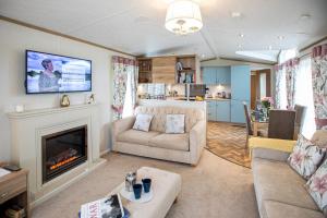 a living room with a couch and a fireplace at Stewart Resort Lodge 25 in St Andrews