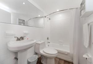 uma casa de banho branca com um WC e um lavatório em The Mariner Suites #31 em Hollywood