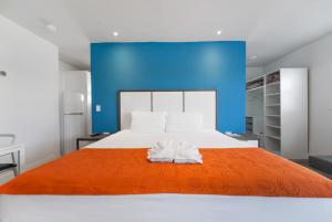 um quarto com uma cama grande e um cobertor laranja em The Mariner Suites #31 em Hollywood