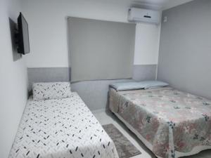 Habitación con 2 camas y TV. en Apartamento aconchegante, en Porto Seguro