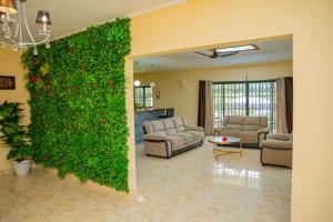una sala de estar con una pared de hiedra verde en Green Park en Beau Vallon