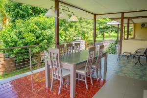 a porch with a table and chairs on it at Green Park in Beau Vallon