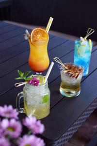 una mesa con tres bebidas en una mesa con flores en Hotel Awis, en Kutno