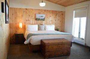 a bedroom with a bed with a wooden wall at 3 Pines Lodge Muskoka in Huntsville