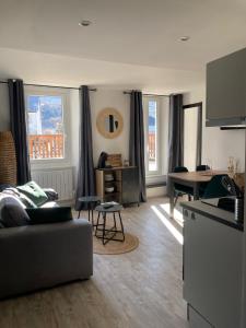una sala de estar con un sofá y una mesa en Le Gaudissart 2, en Barcelonnette